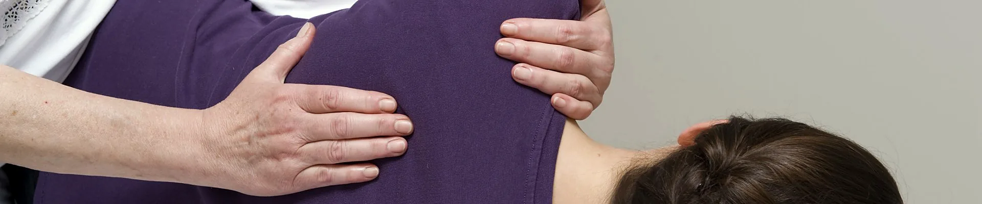 Polarity Körperarbeit in der Naturheilpraxis Dolfi: Hände ruhen auf Rücken und Schulter